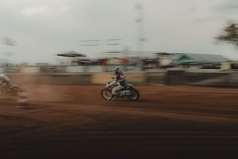 Speedway rider powers a numbered motorcycle across a dirt track